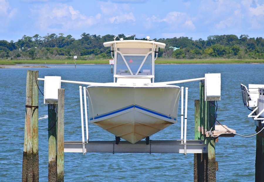 Cradle boat lift raising a runabout out of the water in a covered dock well