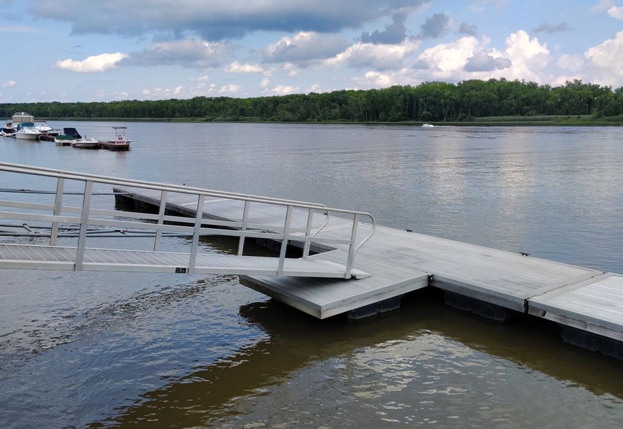 Sealed polyethylene dock floats being installed under a floating dock frame
